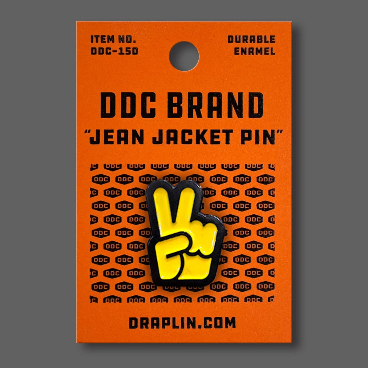 Draplin Design Company yellow peace fingers enamel pin on orange backing card