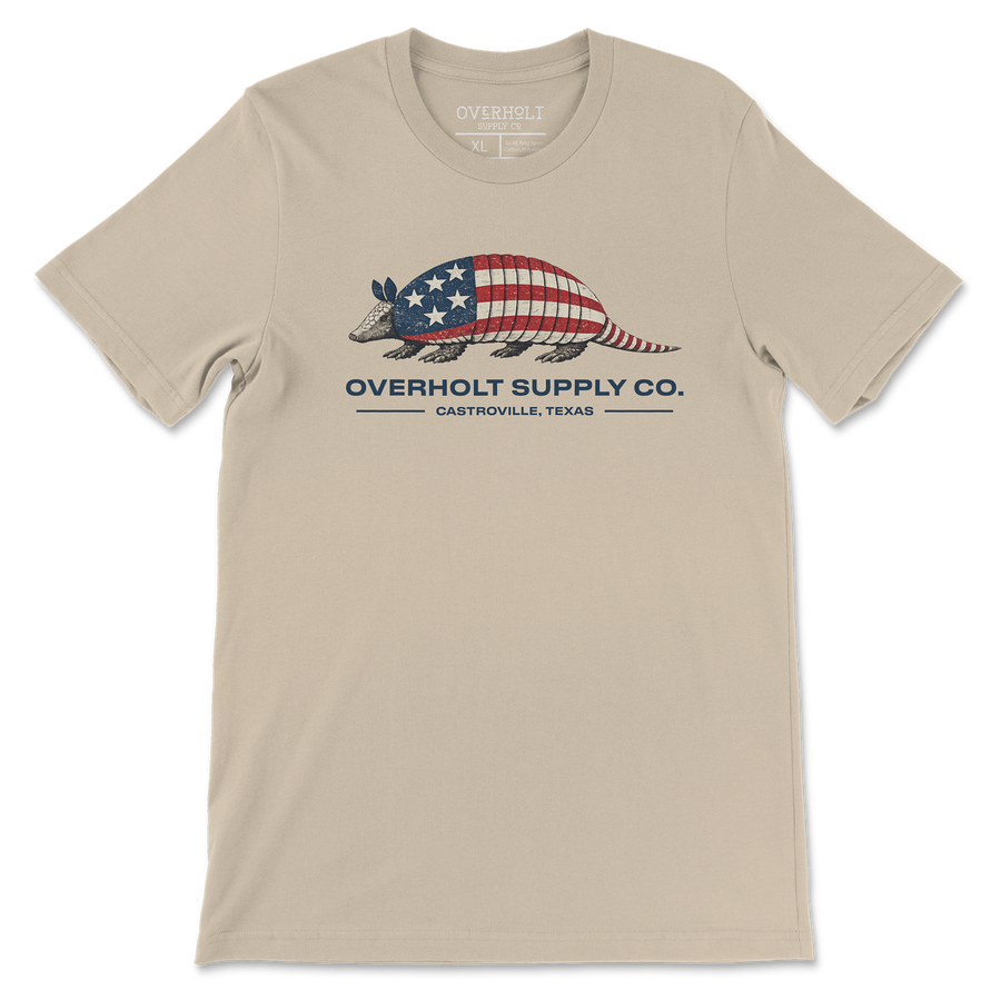 Americana armadillo graphic t-shirt on soft cream Bella and Canvas tee by Overholt Supply Co. featuring red, white, and blue design