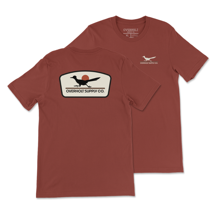 Rust Bella and Canvas T-shirt with a small cream OSC Roadrunner chest print and a large cream, black and rust Roadrunner badge on the back.