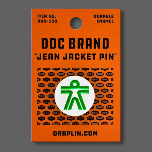 Draplin Design Company Human white enamel pin with green figure on orange backing card