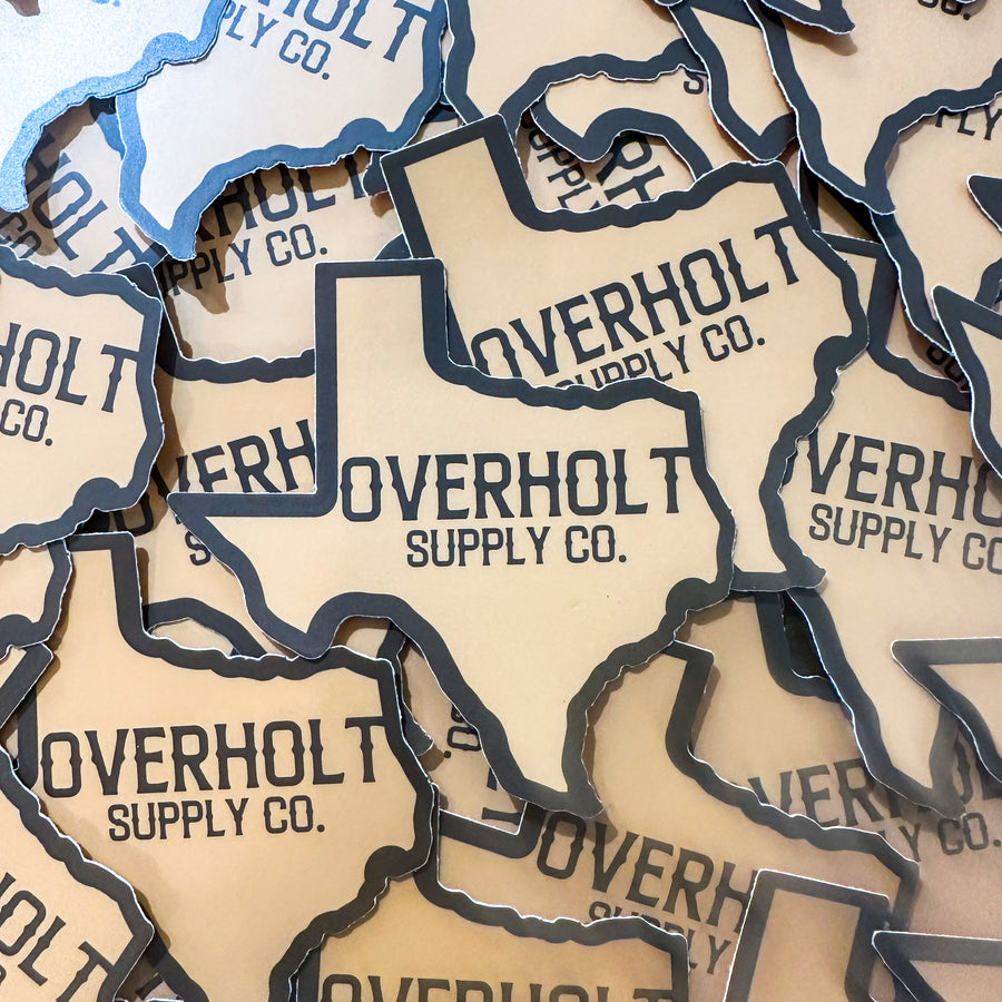 A collection of stickers on top of each other in the shape of Texas with Overholt Supply Co. in the middle